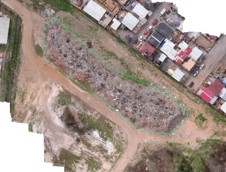 Ortomosaico con el polígono de medición dibujado sobre un acopio de escombros junto a una zona poblada